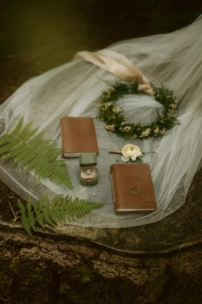 Vow books and wedding details among the moss