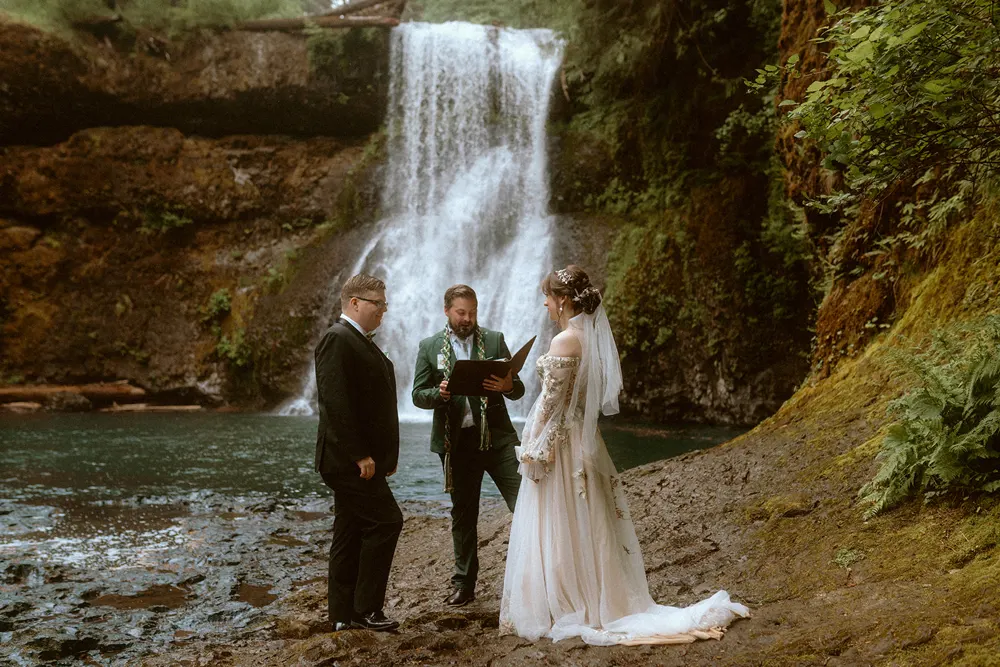 Amelia and David getting married beside the waterfall