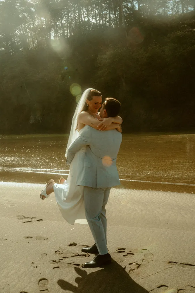 Eric lifting Suzanne on the beach