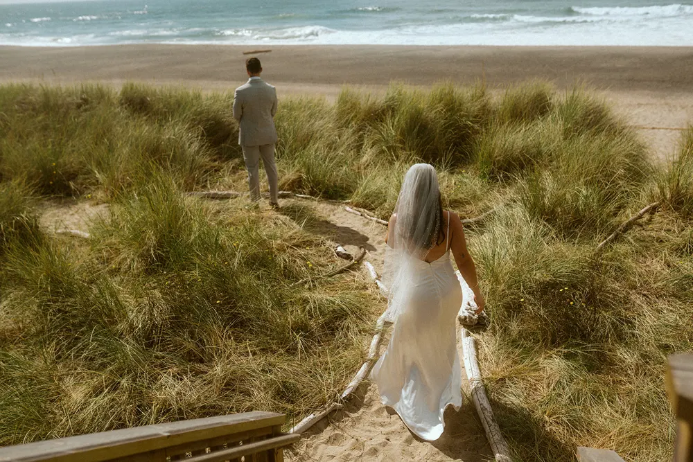 Suzanne walking toward Eric through the coastal grass